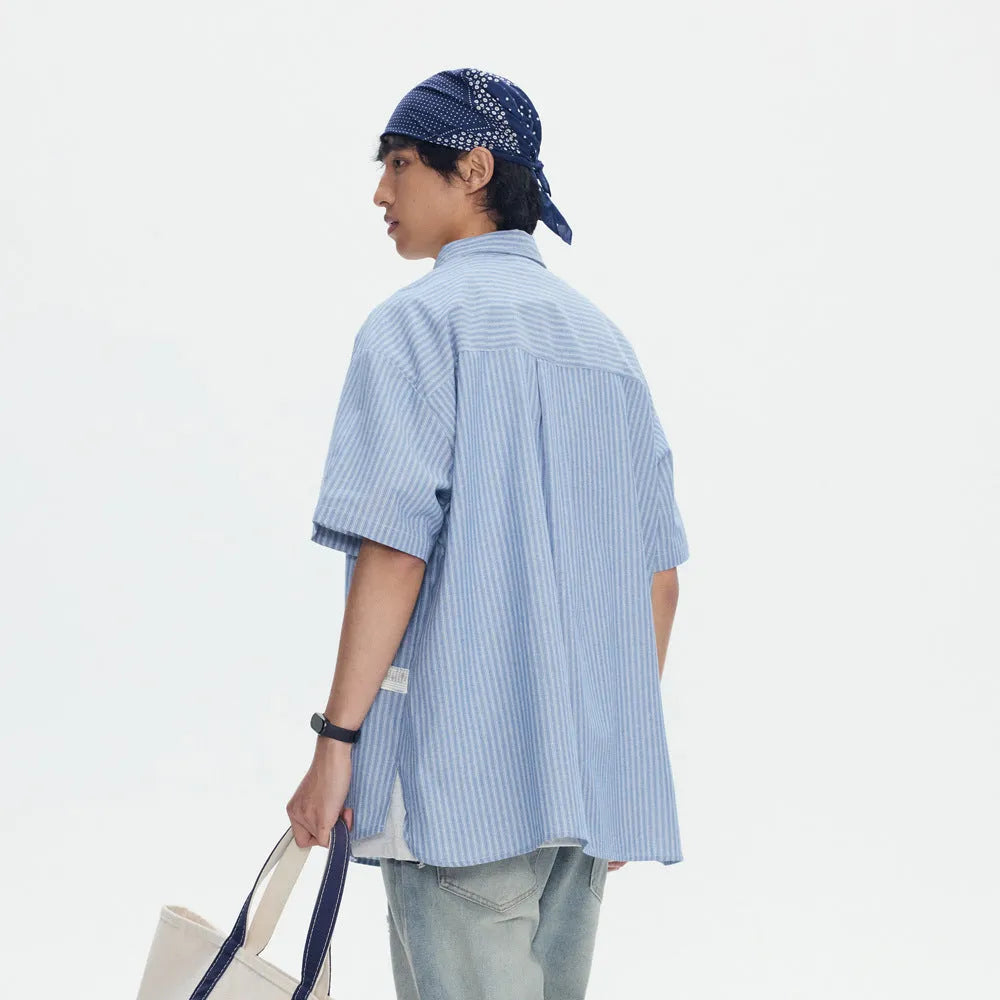 Blue and white striped loose-fit short-sleeved overalls shirt on a hanger
