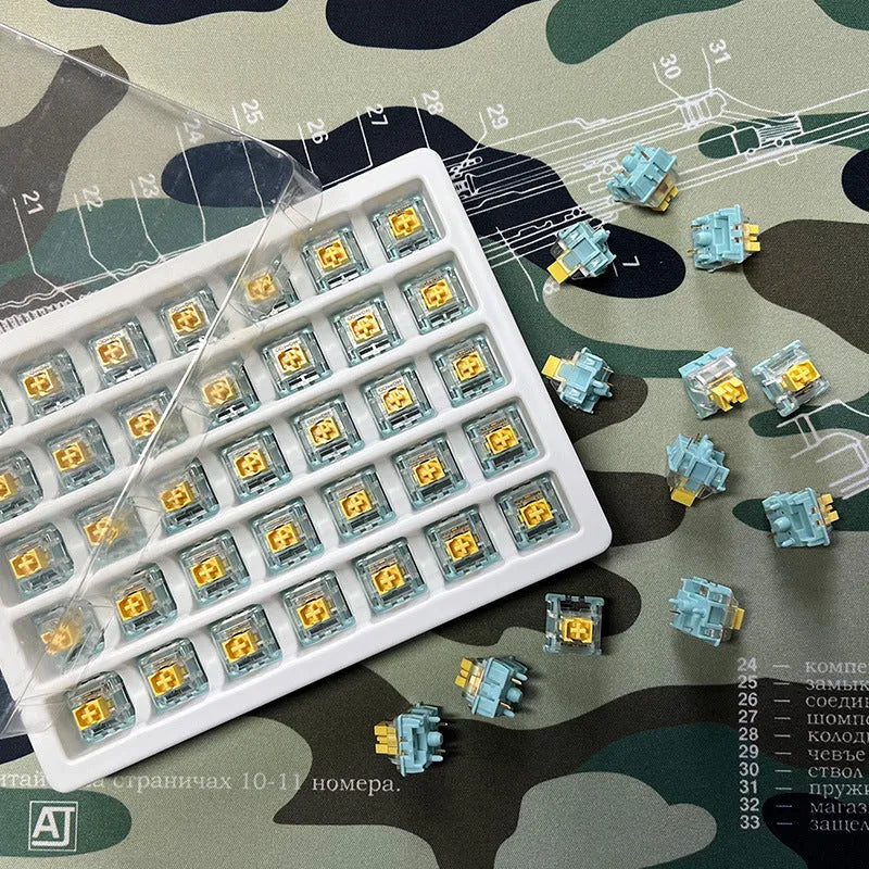 36 clear mechanical keyboard switches with Sea Salt Lemon coloured stems arranged in packaging.