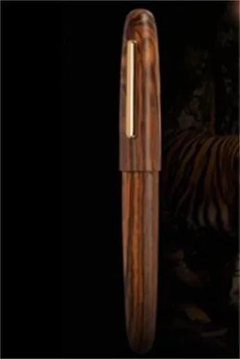 Wooden fountain pen with a rotating cap shown alongside nib options on a desk.