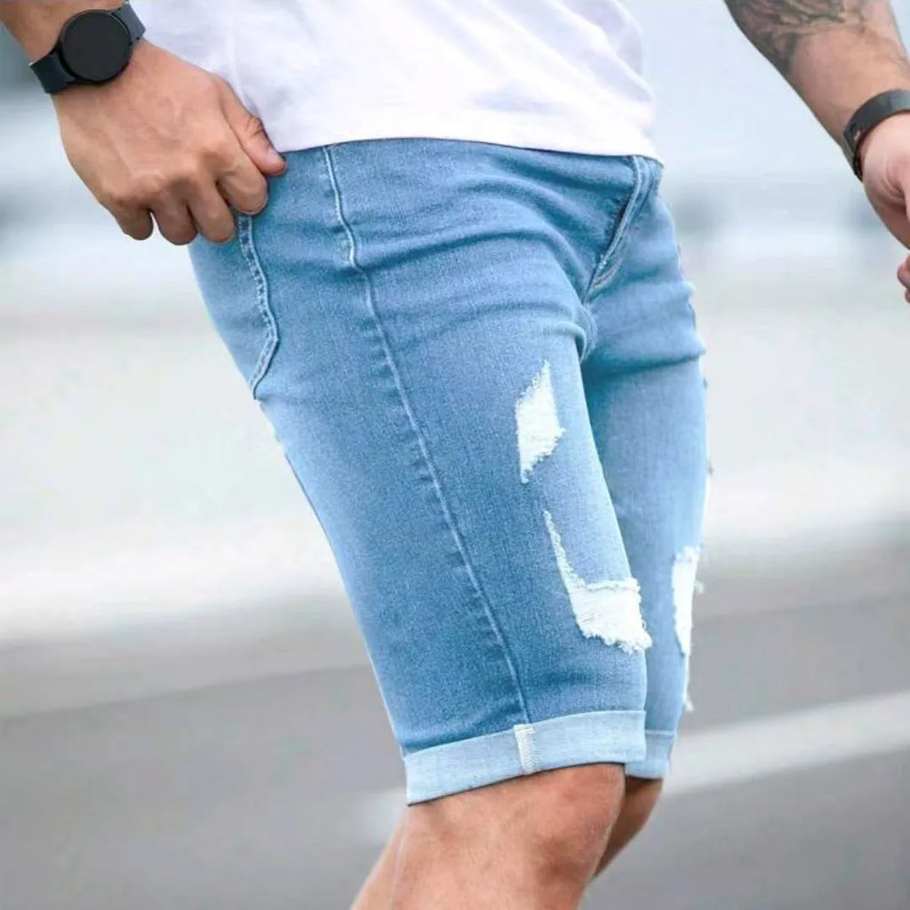 Men's sky blue denim shorts with multi-hole design, low waist, straight fit, and zipper fly on a hanger