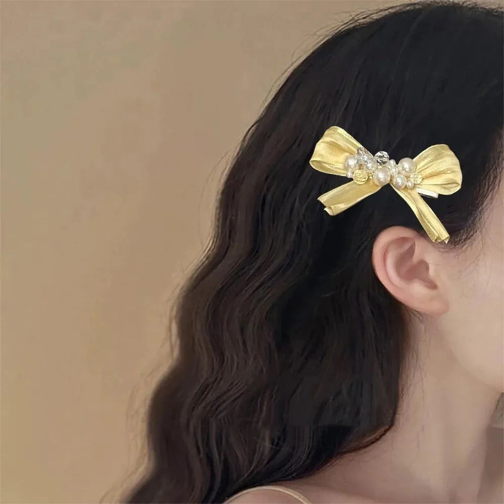 Yellow bow barrette with rhinestone and pearl on plastic duckbill clip for women