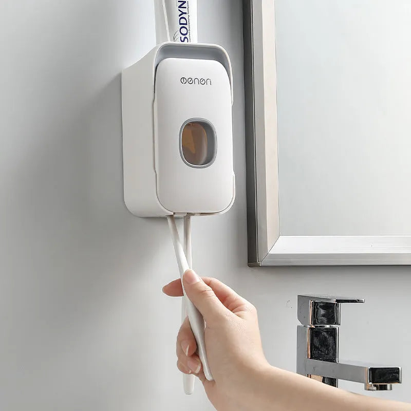Automatic toothpaste dispenser in blue, grey, and pink colours made from ABS plastic.