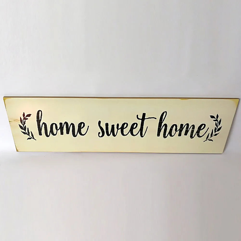 Wooden carved Home Sweet Home hanging pendant decoration in black finish on a light wall