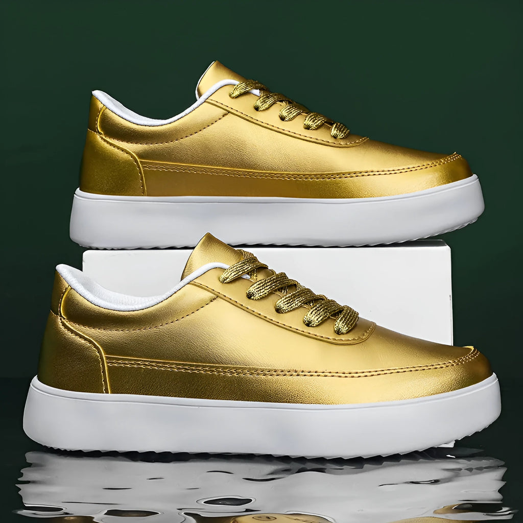 Women's leather flat casual trainers in gold, featuring front lace-up design on a white background.