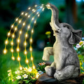 Outdoor resin elephant statue sculpture with LED light strip on garden lawn.