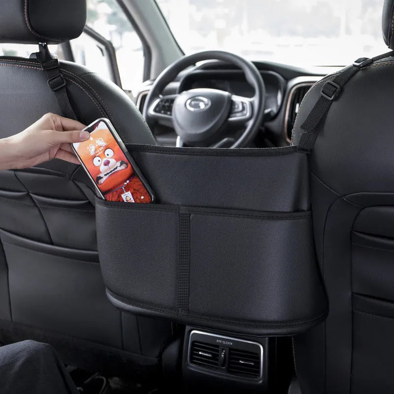 Black leather car seat gap storage bag with a carbon fibre pattern, shown in a vehicle.
