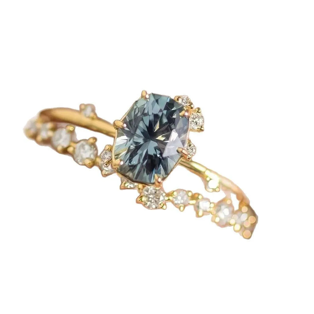 Gold electroplated flower-shaped alloy ring with a central green zircon stone.