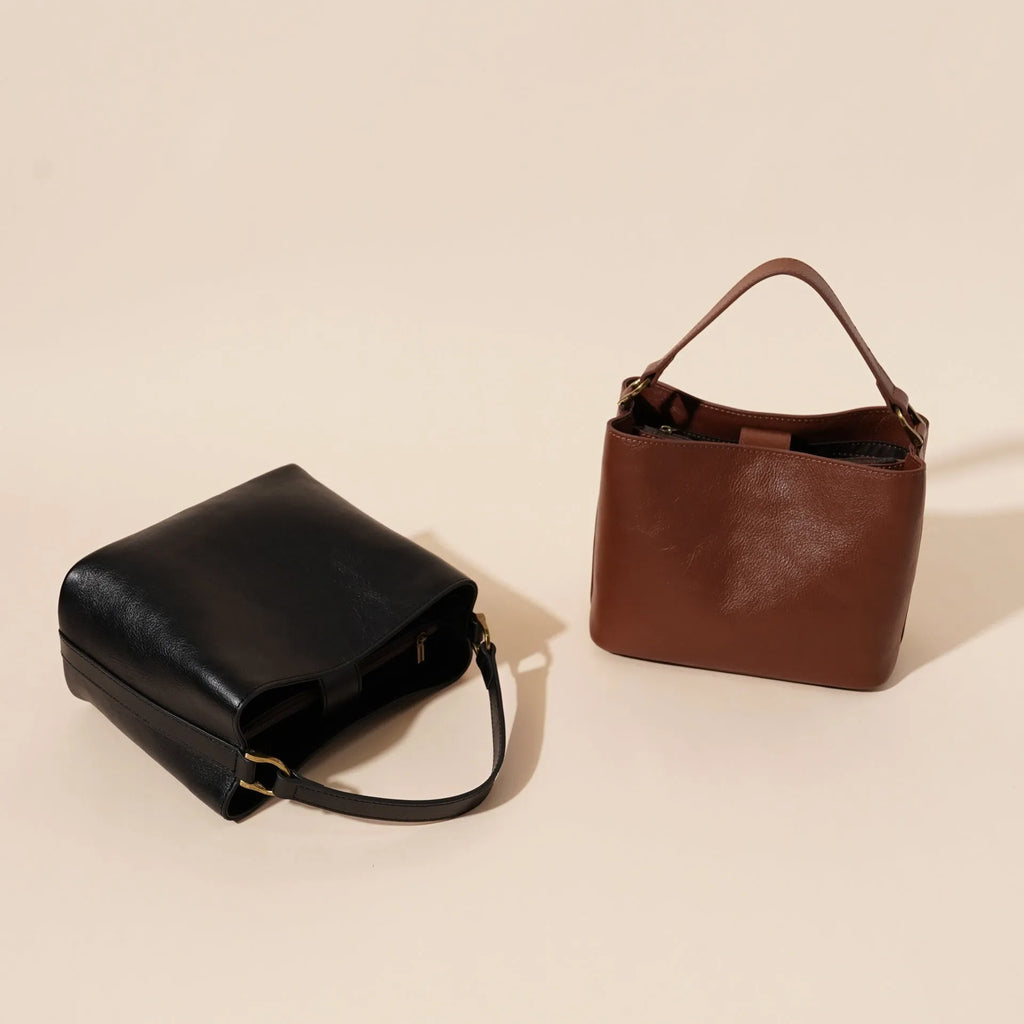 Sugar brown genuine leather women's shoulder handbag with sewing thread detailing on a white background
