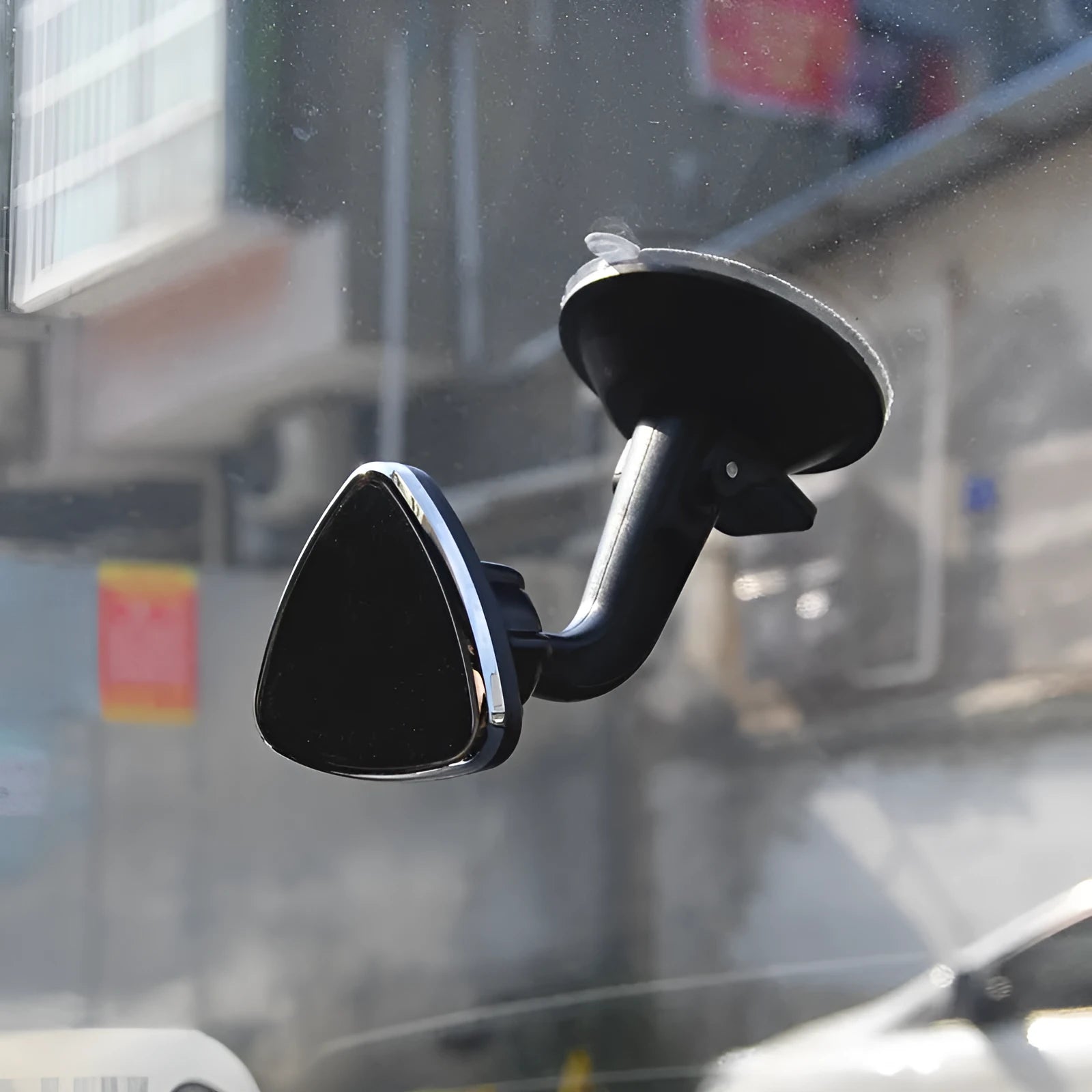 Black magnetic car phone holder with strong magnet mounted on dashboard, holding a smartphone in landscape mode