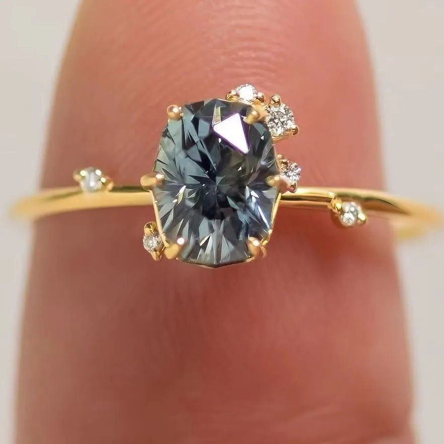 Gold electroplated flower-shaped alloy ring with a central green zircon stone.