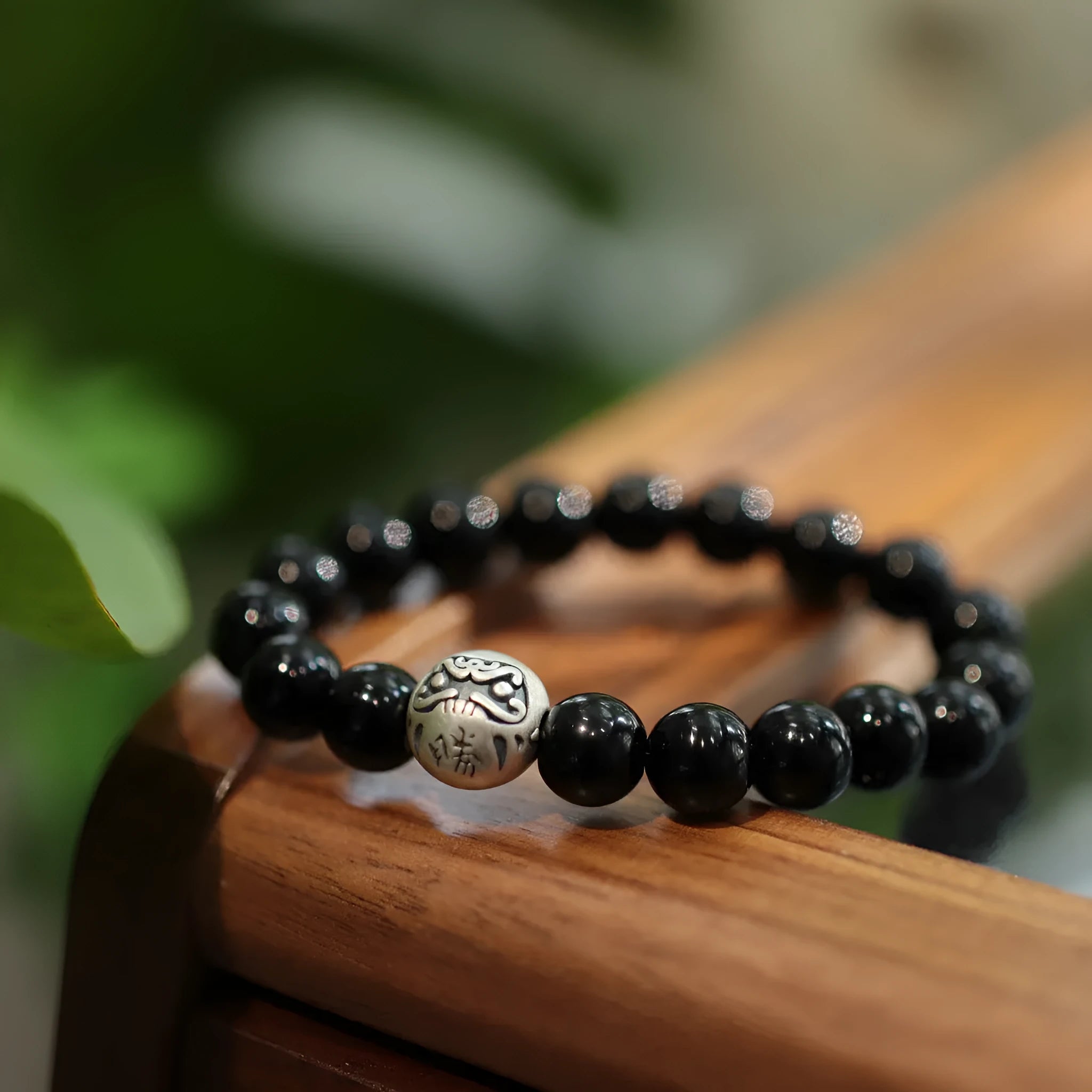 Close-up of a women's bracelet with large 10mm black agate beads on a shiny silver alloy chain in a Chinese style.