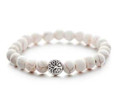 Handmade natural stone bracelet with alloy volcano and white turquoise beads on neutral background