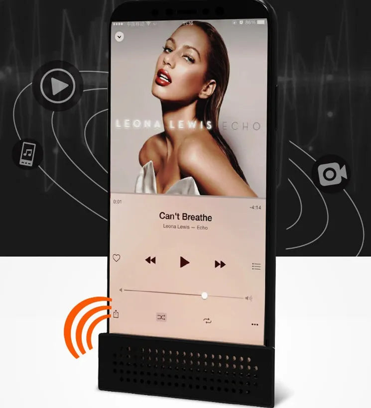 A small, coloured plastic mobile phone amplifier bracket holding an iPhone on a desktop.