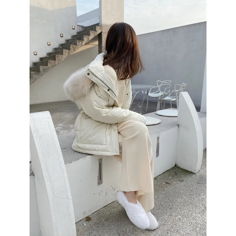 Woman wearing cream white high-waisted knitted wide-leg pants with a drooping mopping silhouette.