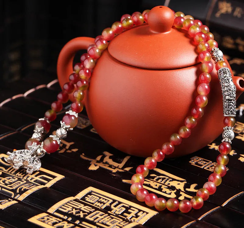 Handmade bracelet with geometric watermelon crystal beads and Chinese knotting in 6mm or 8mm size.