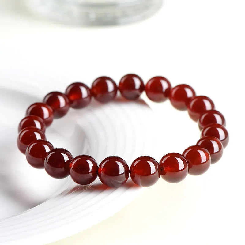 Natural orange red garnet ball bracelet with ruyi charm showing crystal construction and spherical gemstones