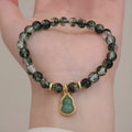 Heart-shaped green phantom quartz crystal bracelet with pearl accents on a neutral background