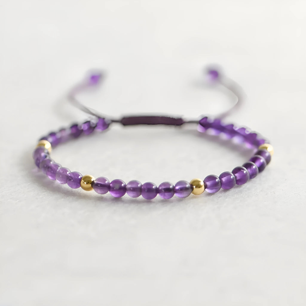 Handmade 4mm natural amethyst bracelet with 14K gold plated accents on a white background