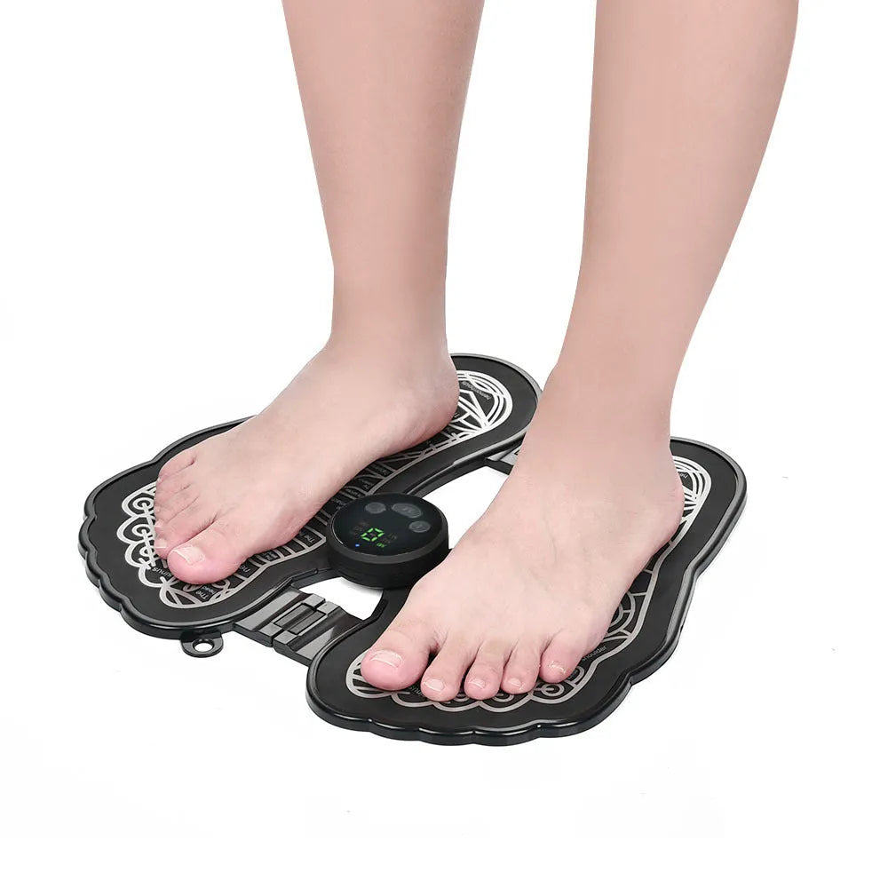 Black rechargeable foldable EMS foot massager pad with control host on floor