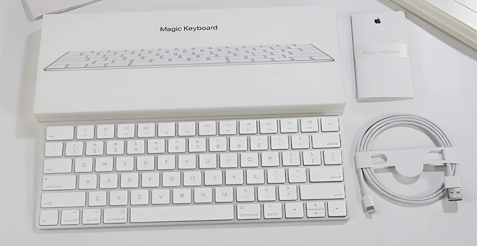 Apple ultra-thin metal Bluetooth wireless keyboard in white on a desk.