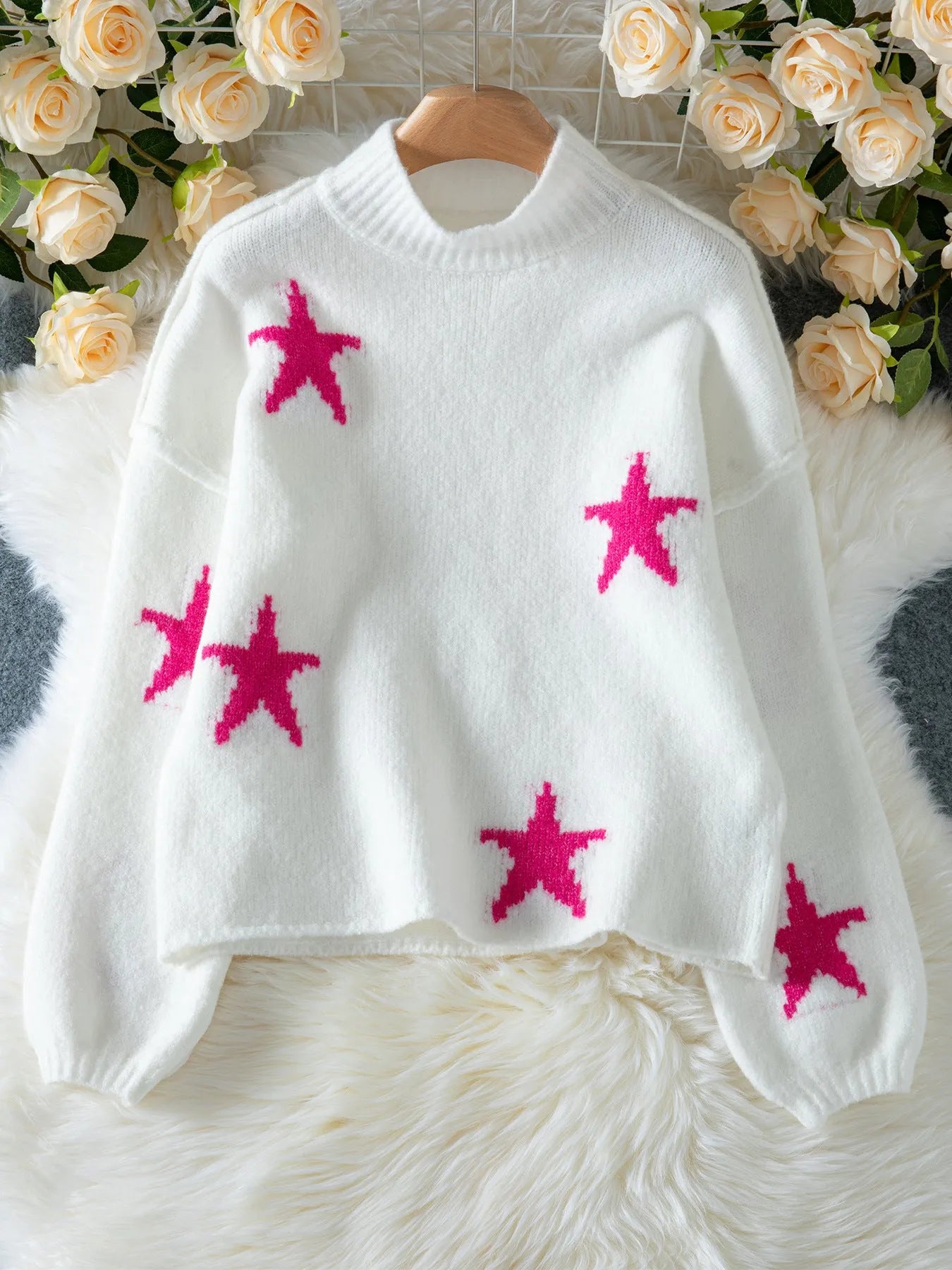 Women's white loose turtleneck pullover sweater with a black five-pointed star pattern on the front.