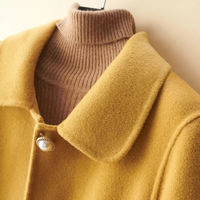 Women's wool double-faced mid-length coat with pearl buckle, doll collar, and front pockets in solid colour