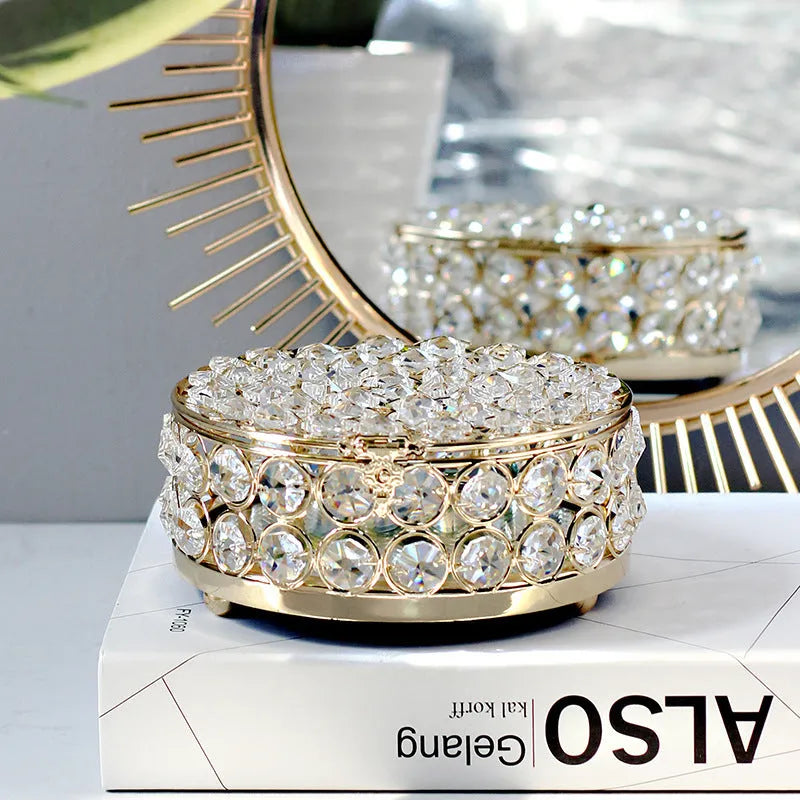 Clear crystal glass jewellery box with a French gold metal frame on a table.