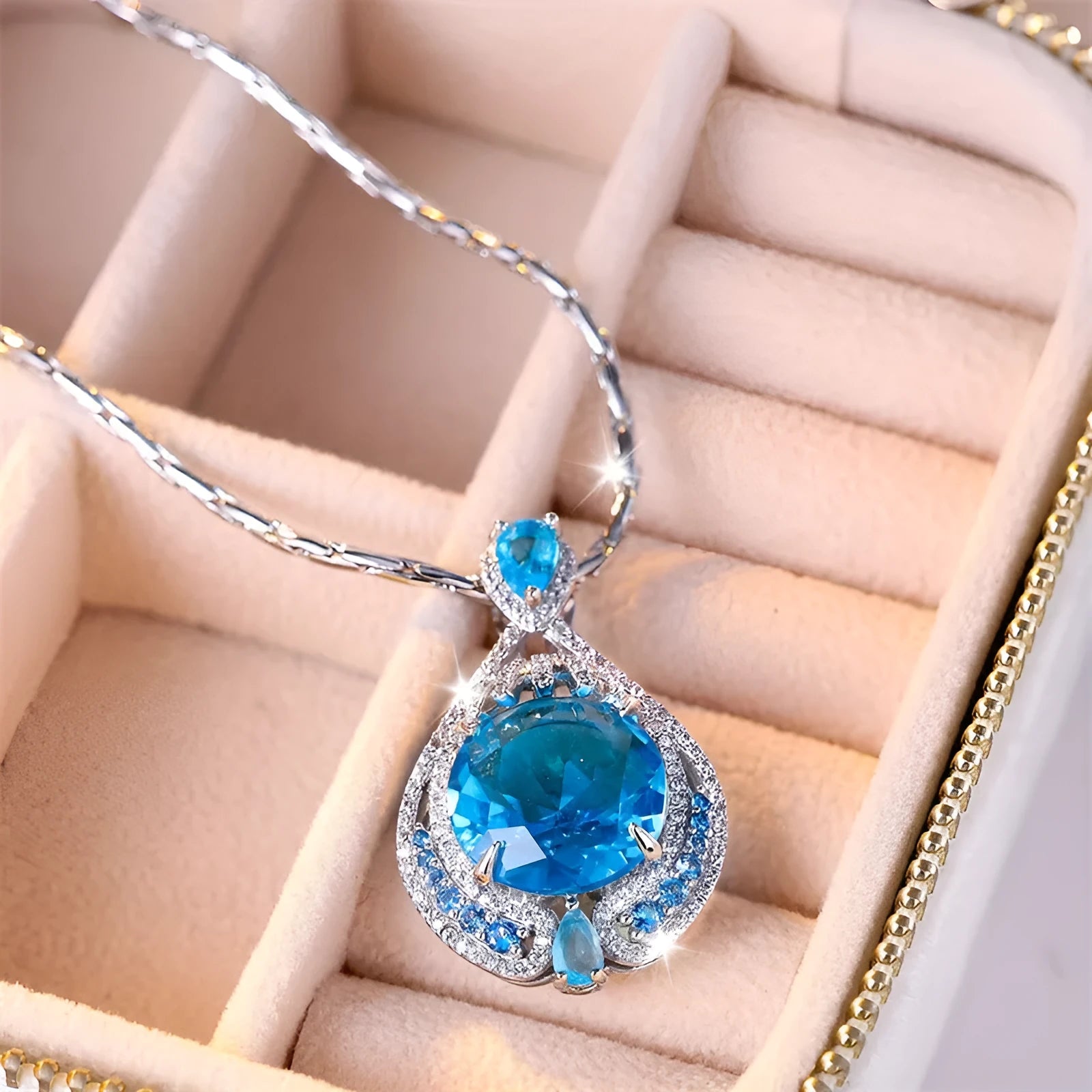 Close-up of a women's geometric necklace with a blue crystal pendant on a water wave chain.