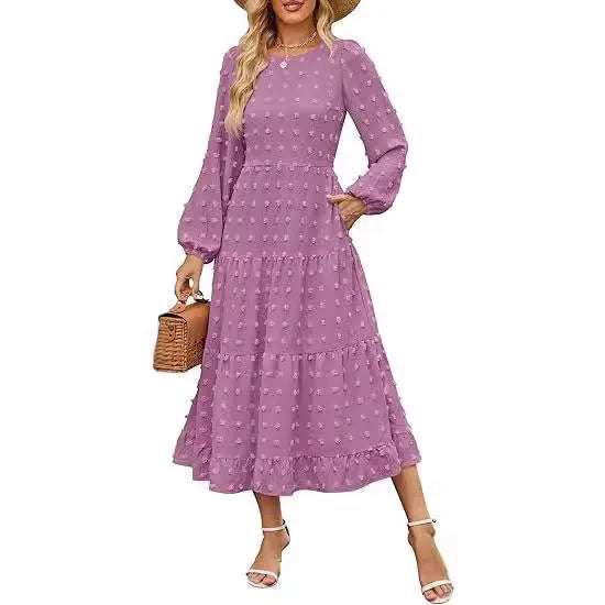 A woman wearing a beige high waist long sleeve dress with ruffle details on a autumn day.