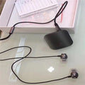 A black Bluetooth lavalier headset worn around the neck with a single earpiece, showing wireless design.