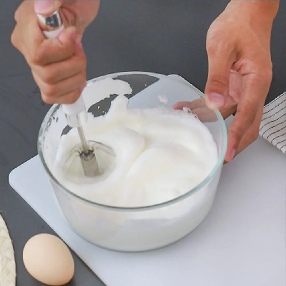 Semi-automatic stainless steel egg beater whisk with hand pressure rotating handle, silvery colour, on white background