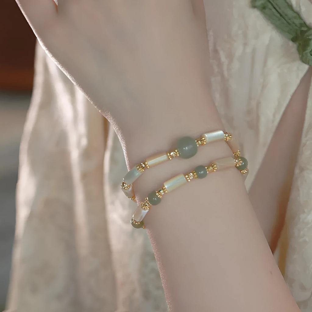 Natural Hetian jade white lip shell round bead bracelet for women on a neutral background