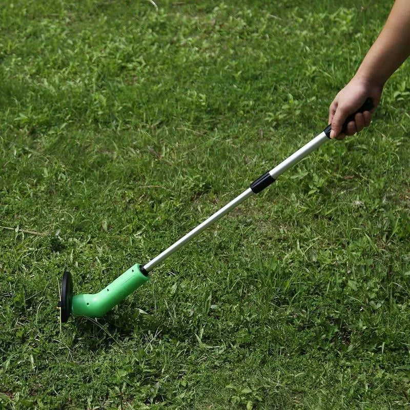 Cordless lawn trimmer with lightweight extension pole and protective debris shield on grass