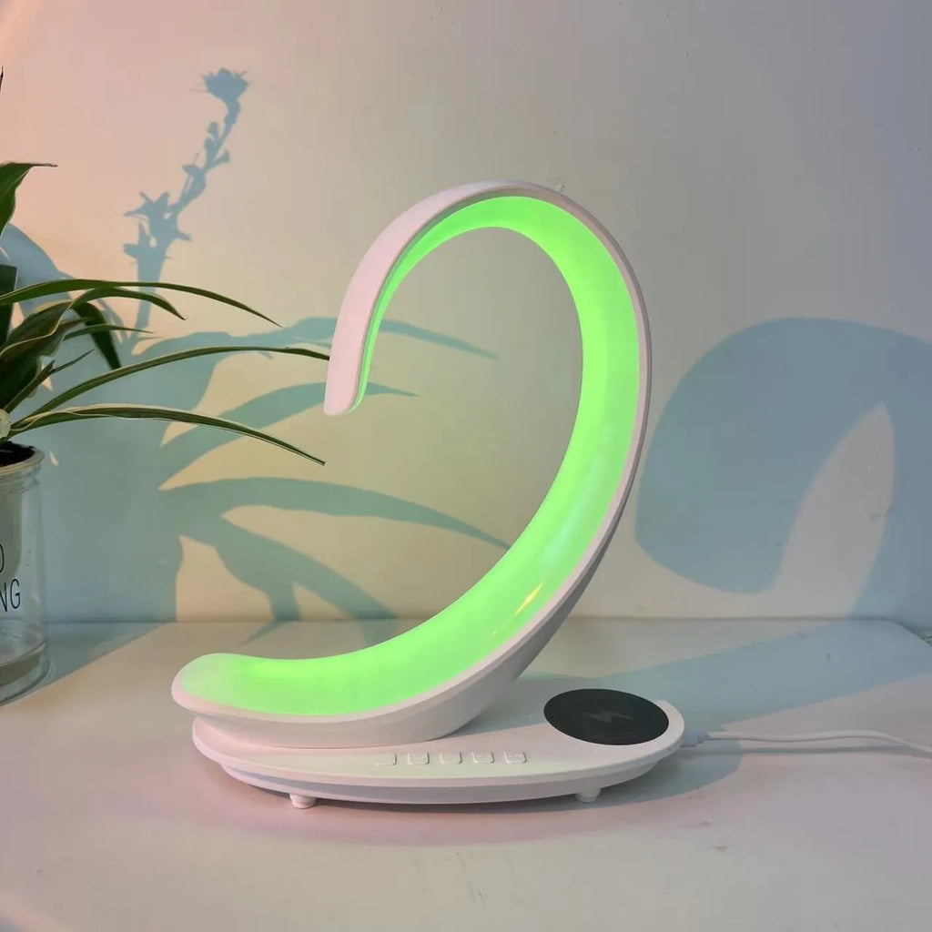 White swan-shaped desk lamp with wireless charging pad and Bluetooth speaker, showing colourful LED lights.