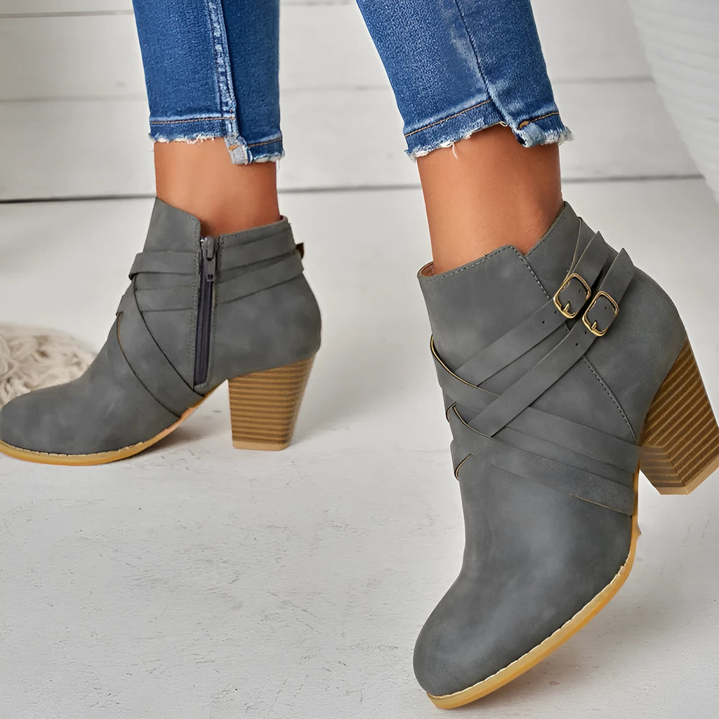 Women's grey short boot with 7cm heel, side zipper, and belt buckle detail on a rubber sole.