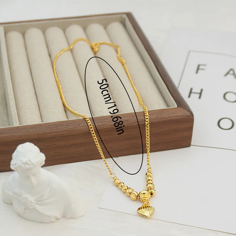 Copper geometric heart pendant necklace with electroplated finish on white background