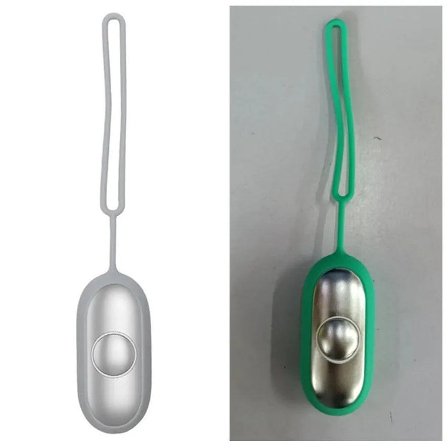 Hand-held micro-current sleep aid device in grey, with round button and micro USB port, on a desk