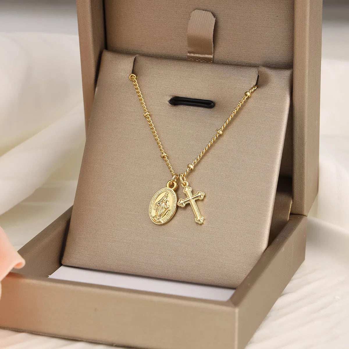 Gold geometric cross Virgin Mary necklace for women on display