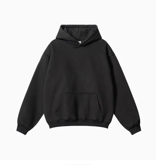 Man wearing a loose fit grey cotton terry hooded sweater with drop-shoulder sleeves.