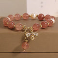 Women's beaded bracelet with strawberry quartz stones, freshwater pearls, and zircon accents on alloy.
