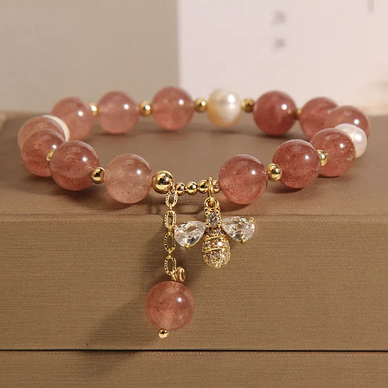 Women's beaded bracelet with strawberry quartz stones, freshwater pearls, and zircon accents on alloy.