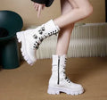 Women's black knee-high boots with metal buckle straps and a side zipper closure.