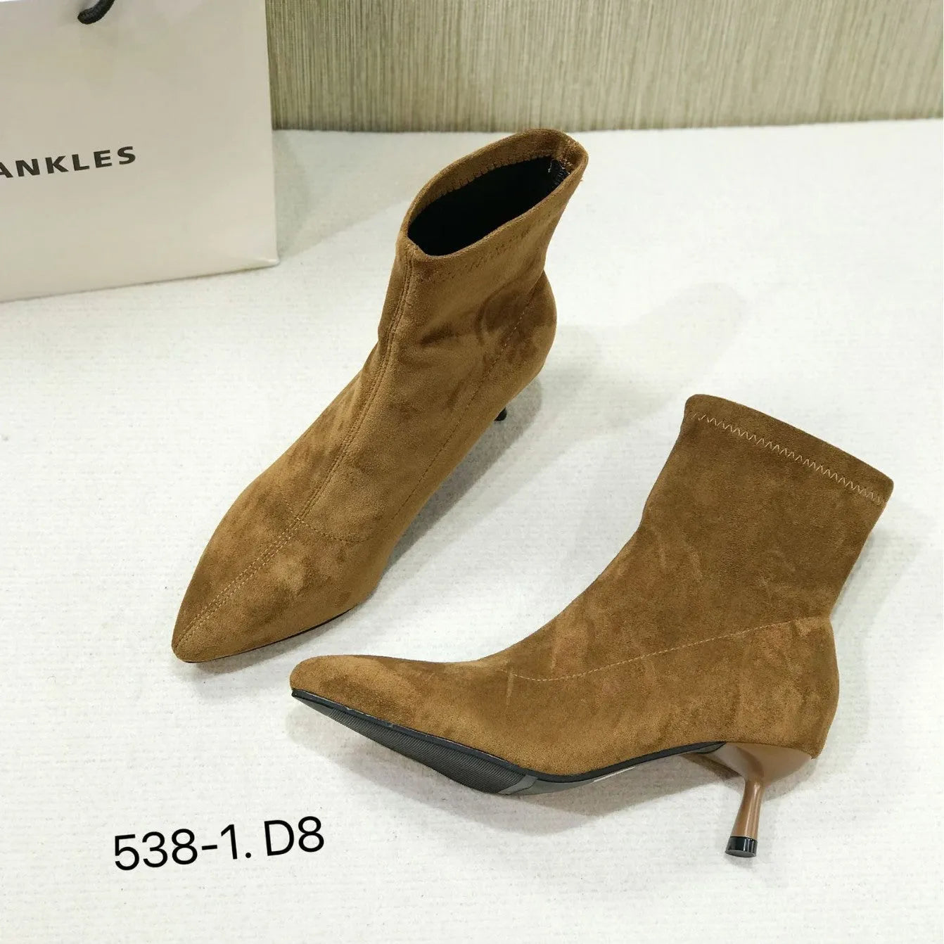 Women's black pointed toe ankle boots with a stiletto heel on a plain background