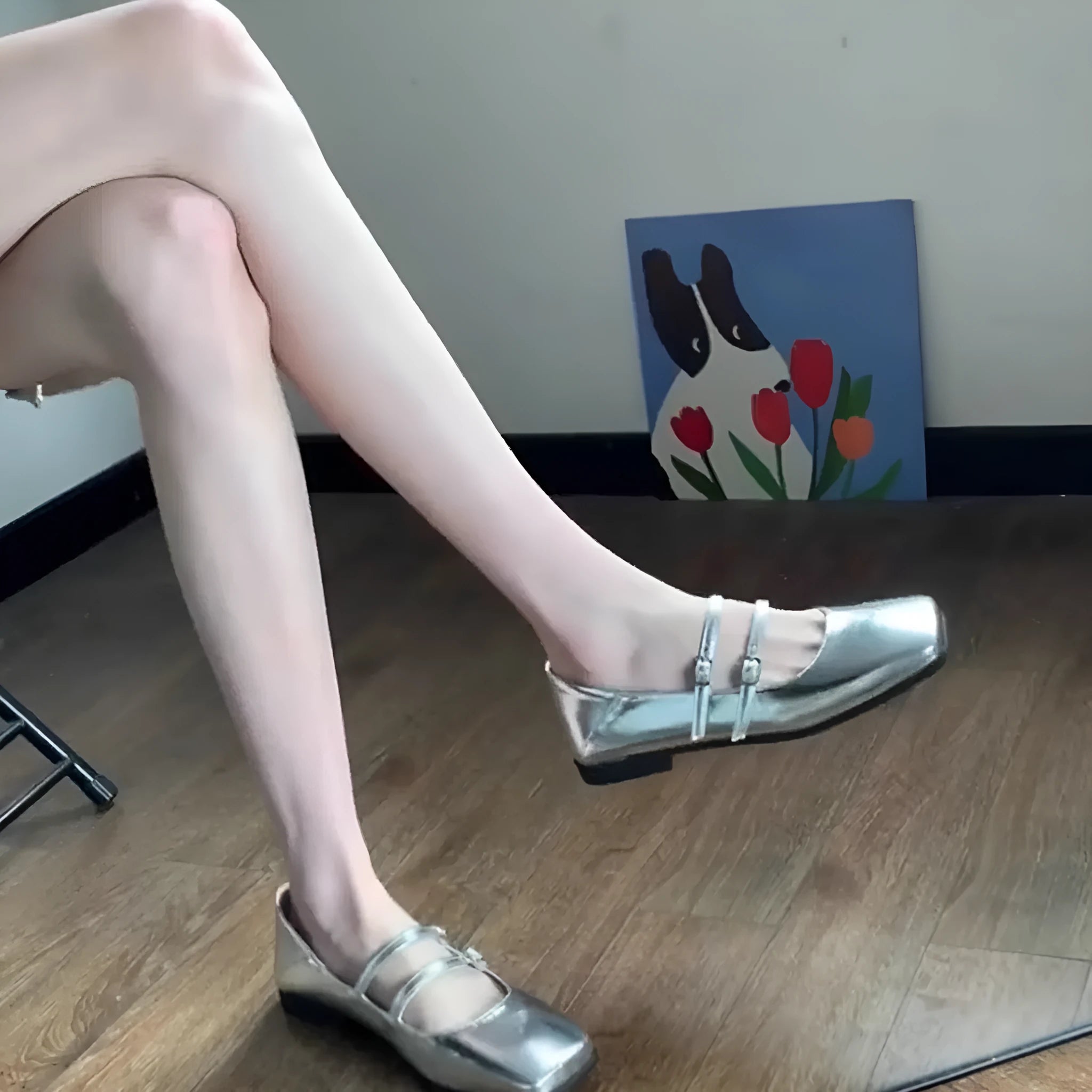 Women's silver leather Mary Jane pumps with a cross buckle strap and flat sole.