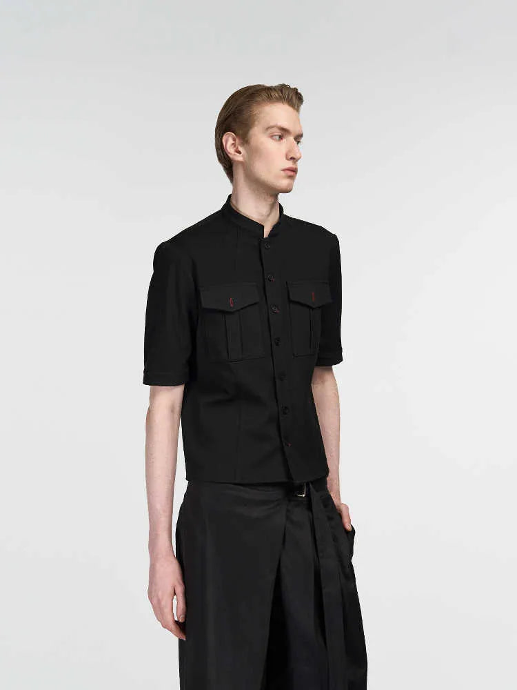 Handmade black loose fit half sleeve hunting shirt with a shirt collar, laid flat.