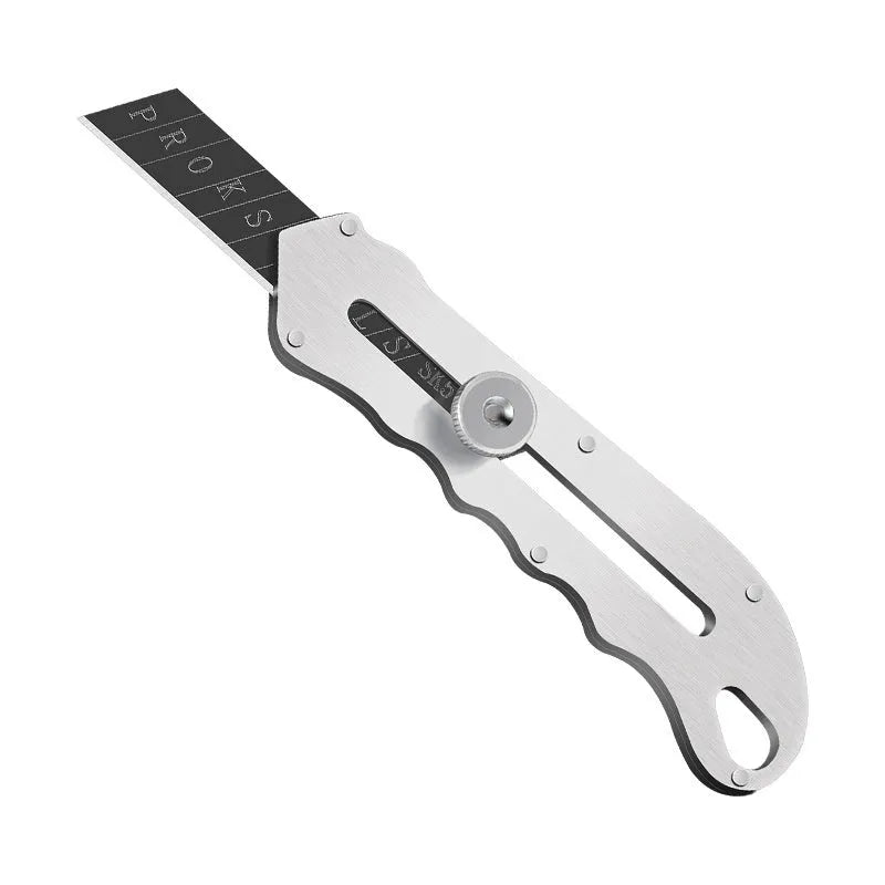 Stainless steel folding art knife with black blade and 20 spare blades on a work surface