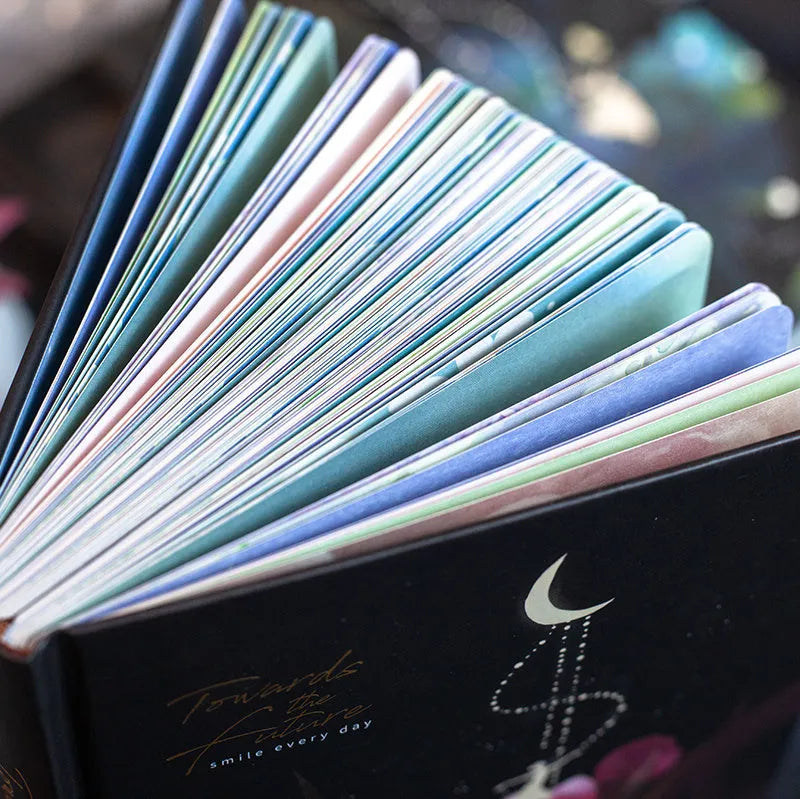 A5 notebook with luminous colourful illustration cover shown in deep blue, gold, light blue, and purple colour options.