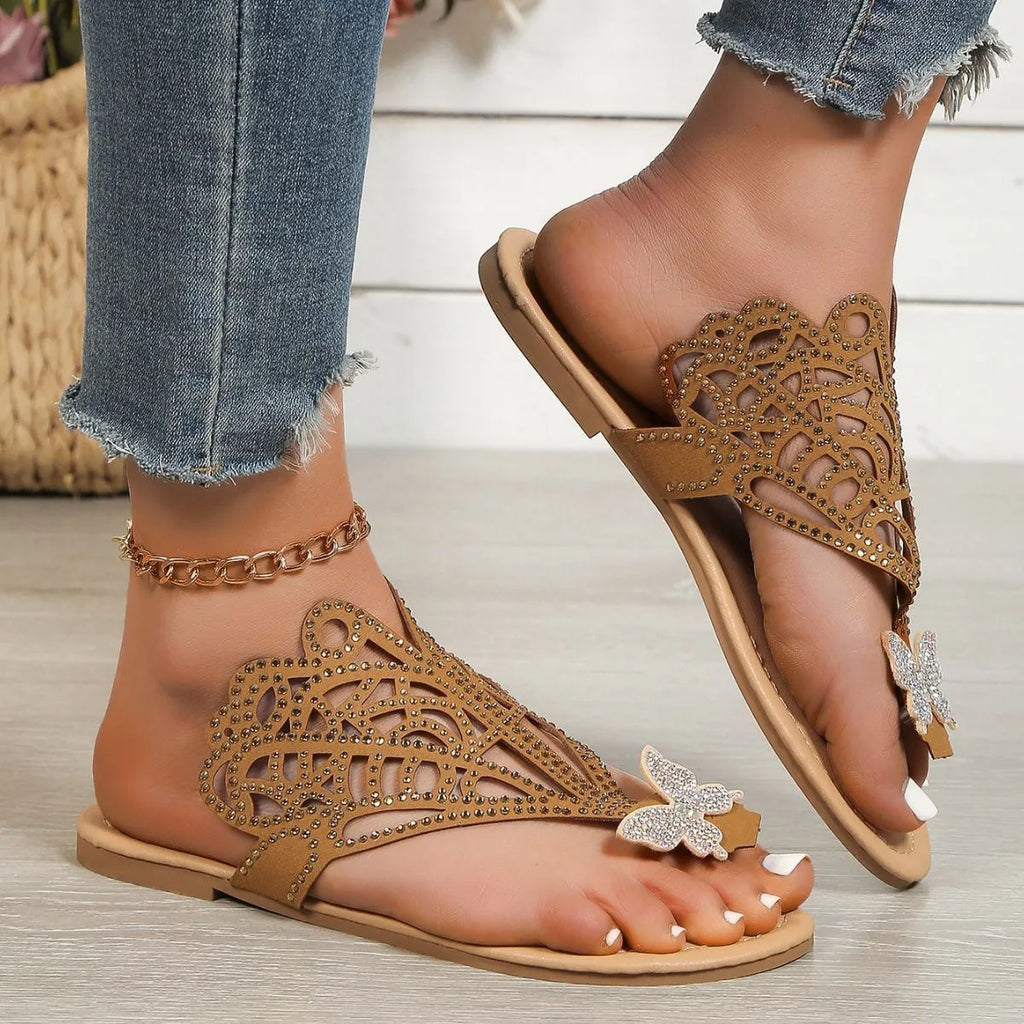 Women's black slip-on sandals with rhinestone accents and flip-toe design on flat rubber sole
