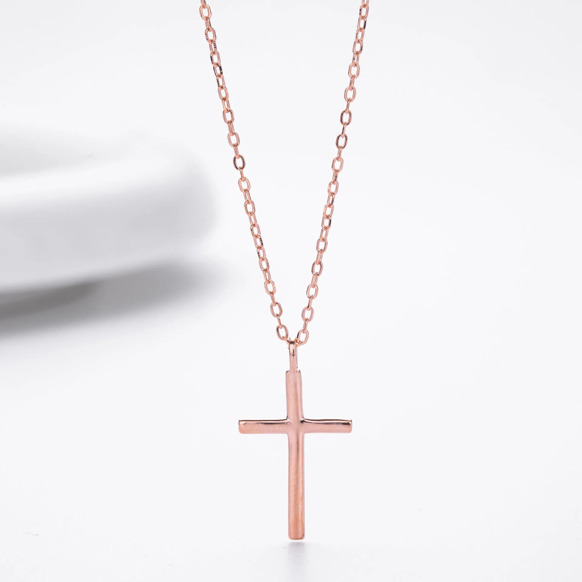 Simple glossy cross pendant on a sterling silver O-chain necklace.