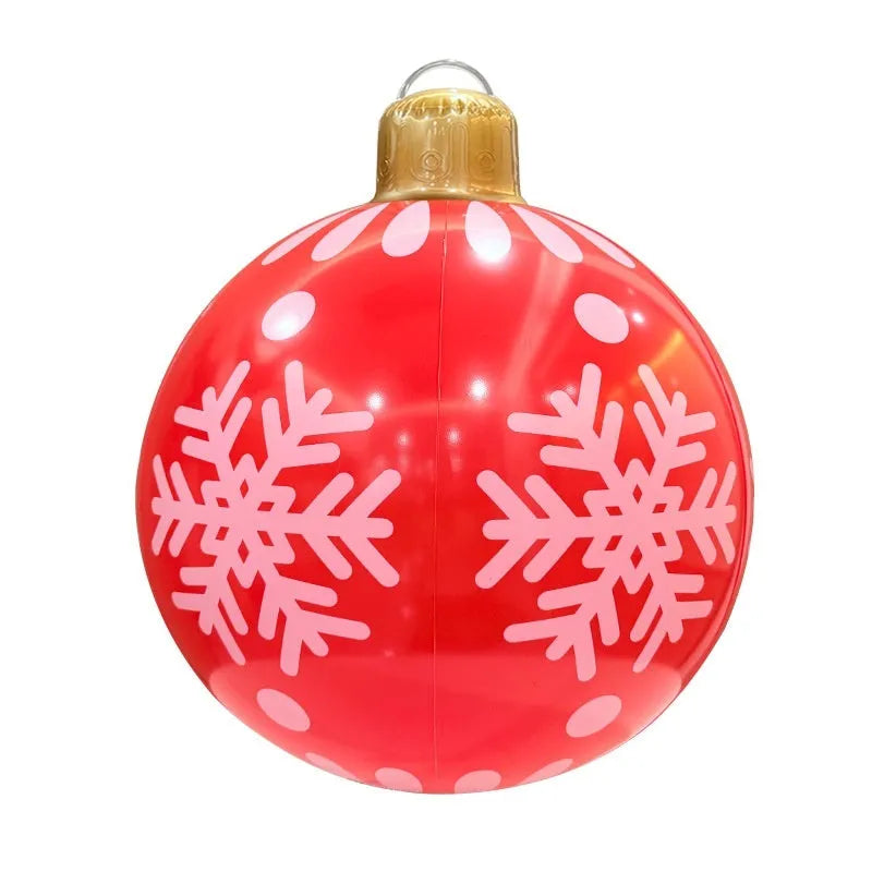 Large red inflatable Christmas ball with LED lights in a garden setting